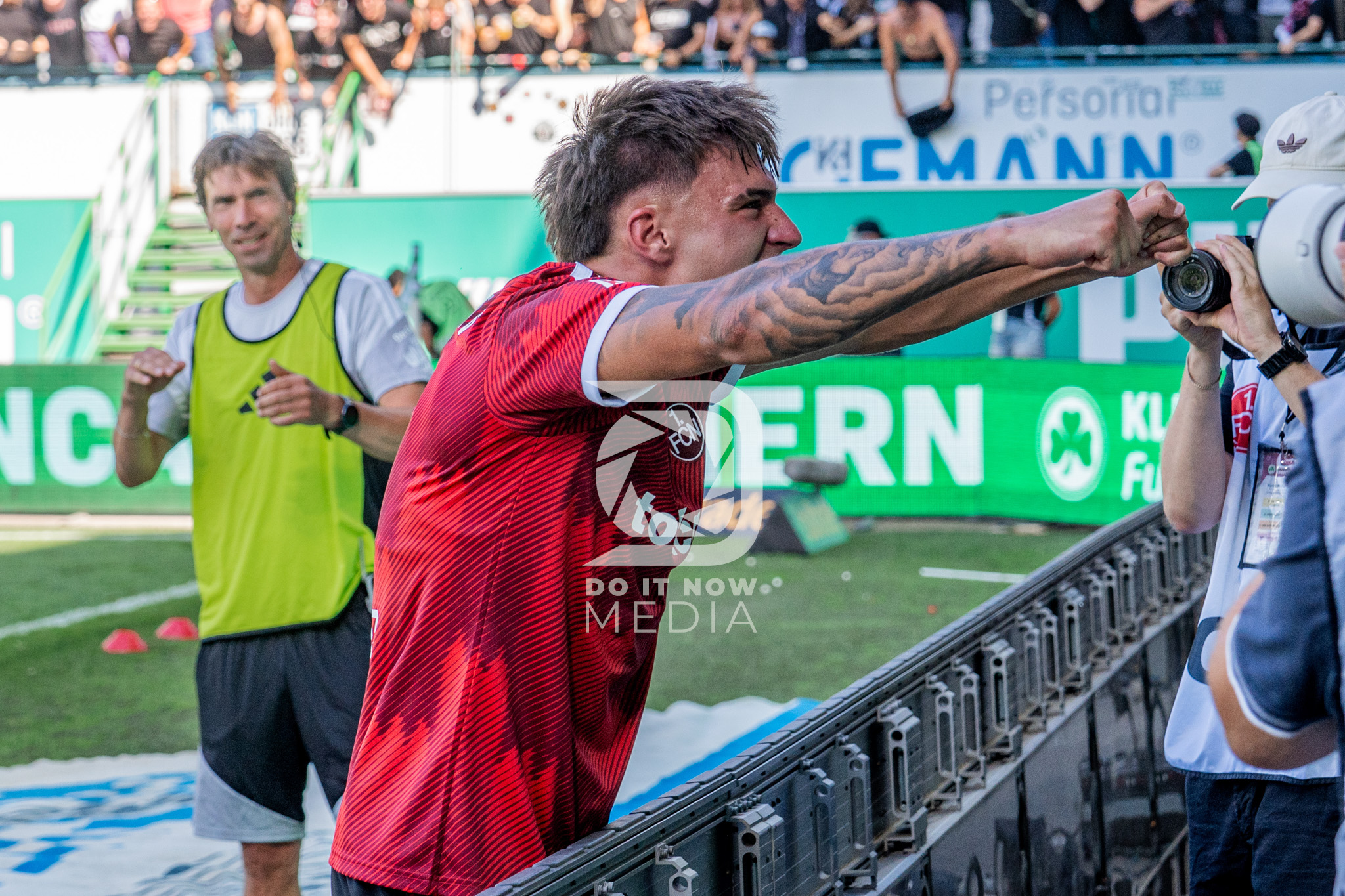 Ein Nürnberger Spieler jubelt vor den Fotografen an der Seitenlinie.