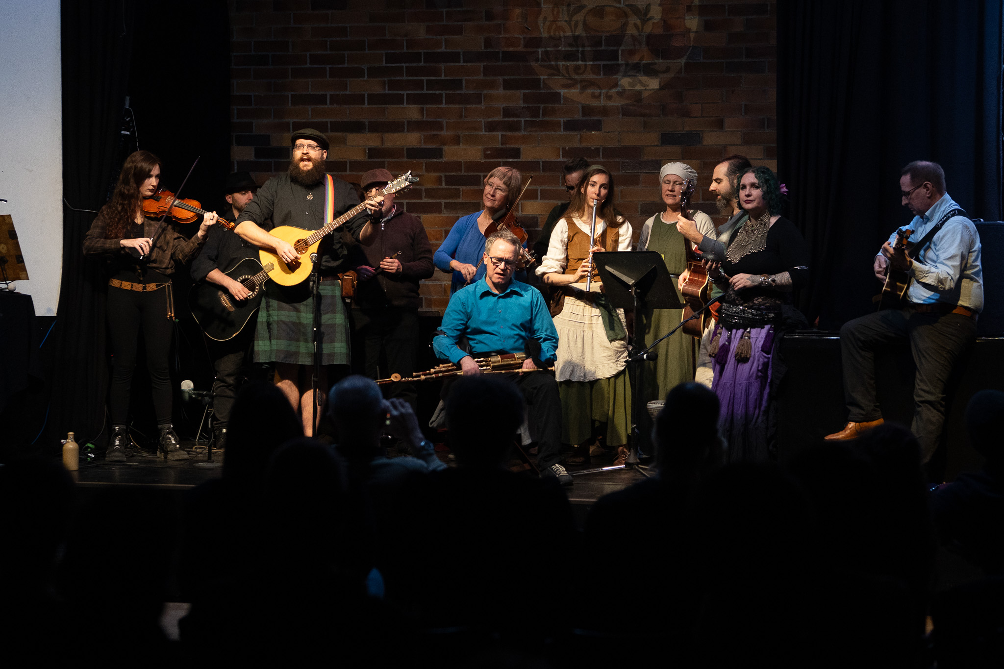 Musikerinnen und Musiker gemeinsam auf der Bühne der Folktaverne
