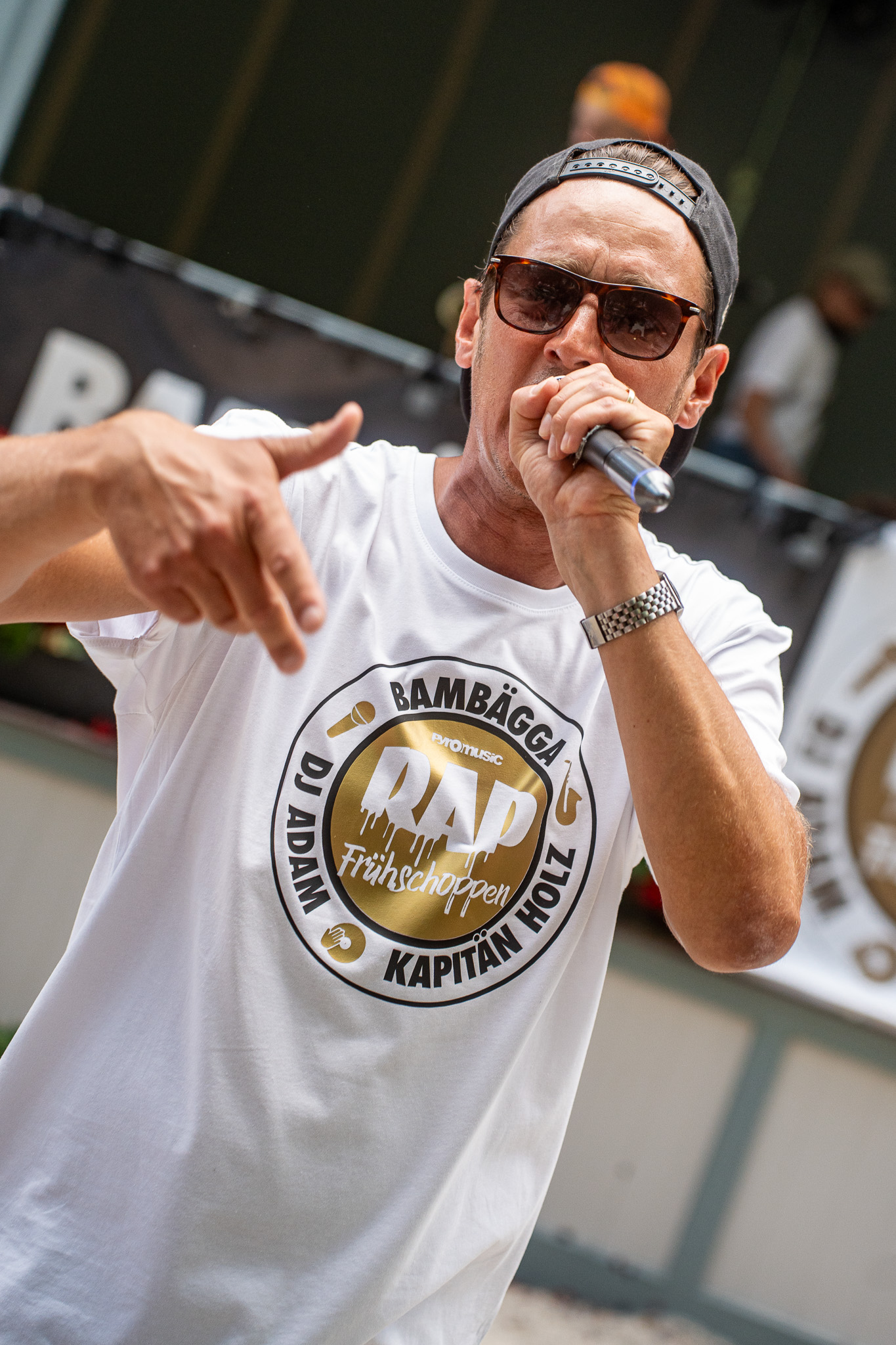 Bambägga tritt mit Mikrofon und Sonnenbrille im Spezi-Keller auf.