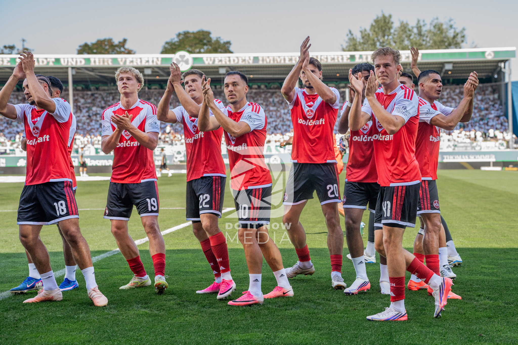 Spieler des 1. FC Nürnberg applaudieren auf dem Spielfeld.