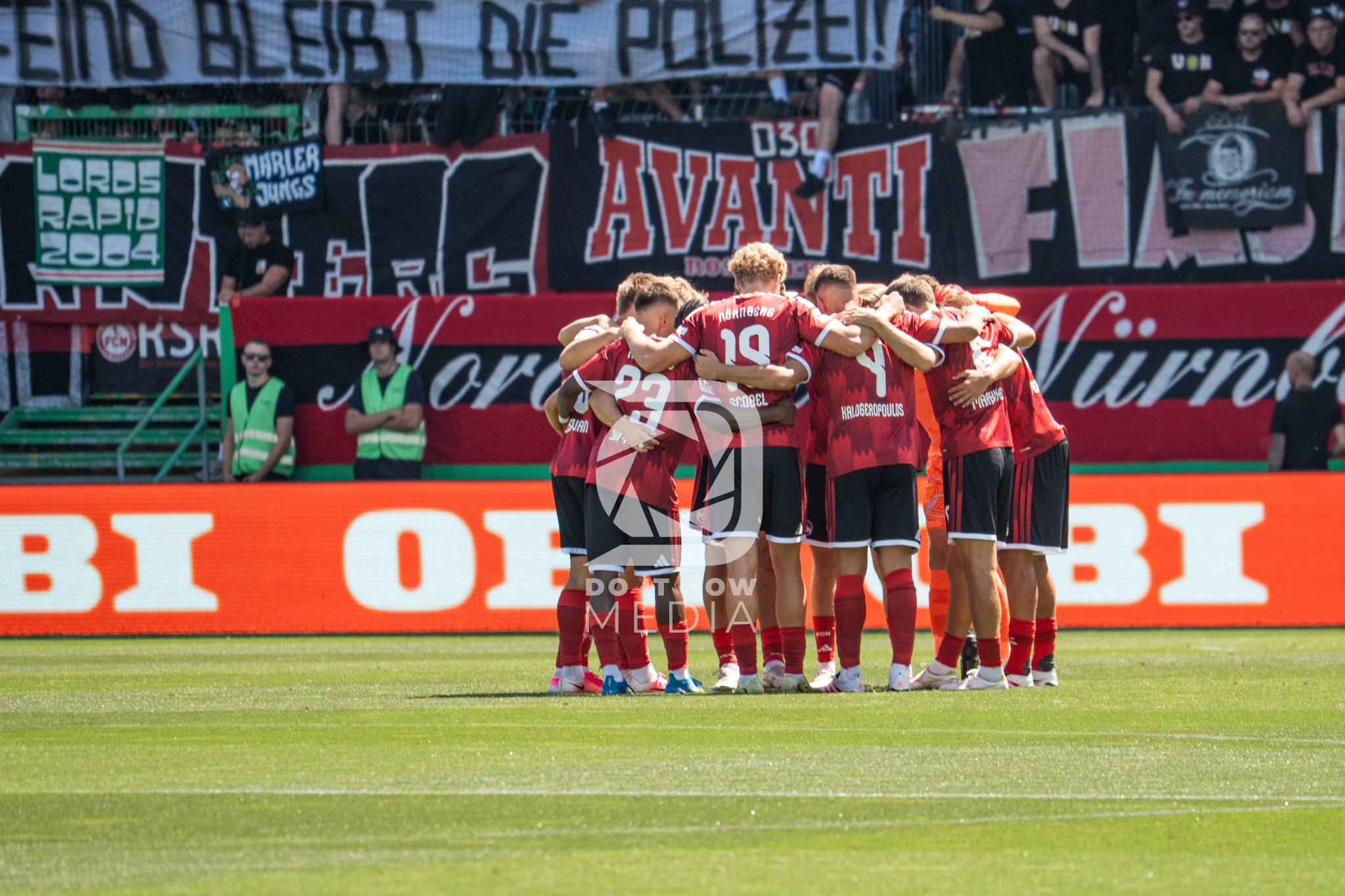 FCN-Spieler bilden einen Mannschaftskreis vor dem Gästeblock.