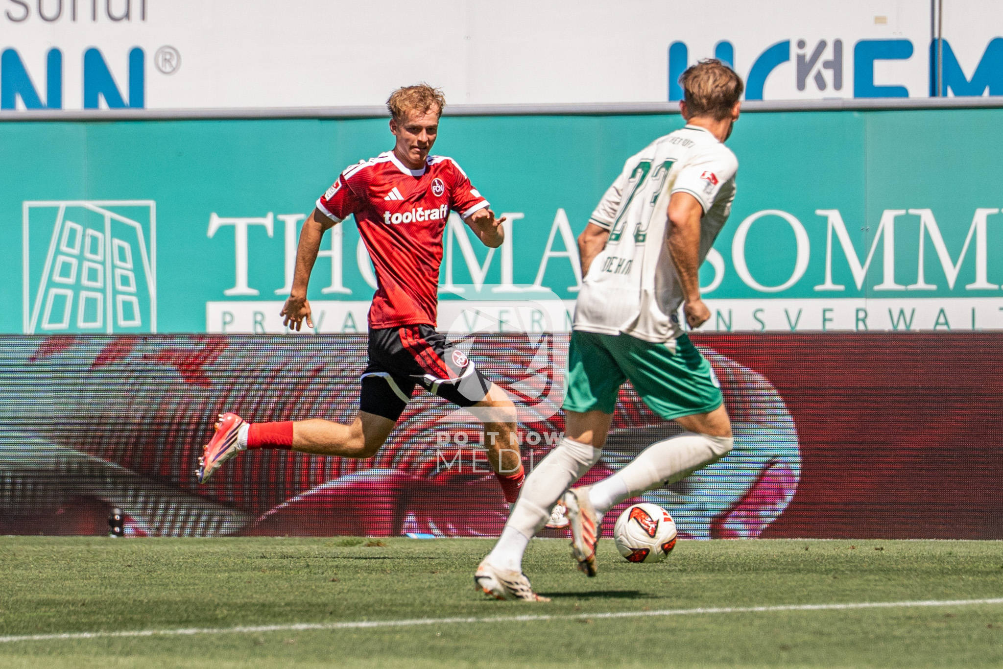 Ein FCN-Spieler verfolgt einen Fürther Gegenspieler am Ball.
