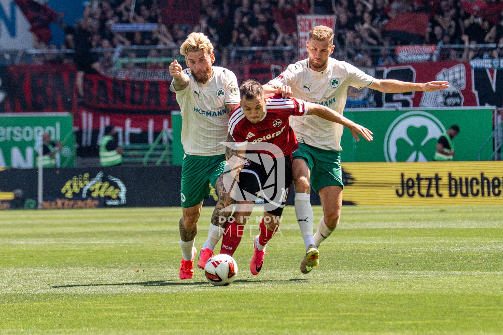 Ein FCN-Spieler behauptet den Ball gegen zwei Fürther Gegenspieler.